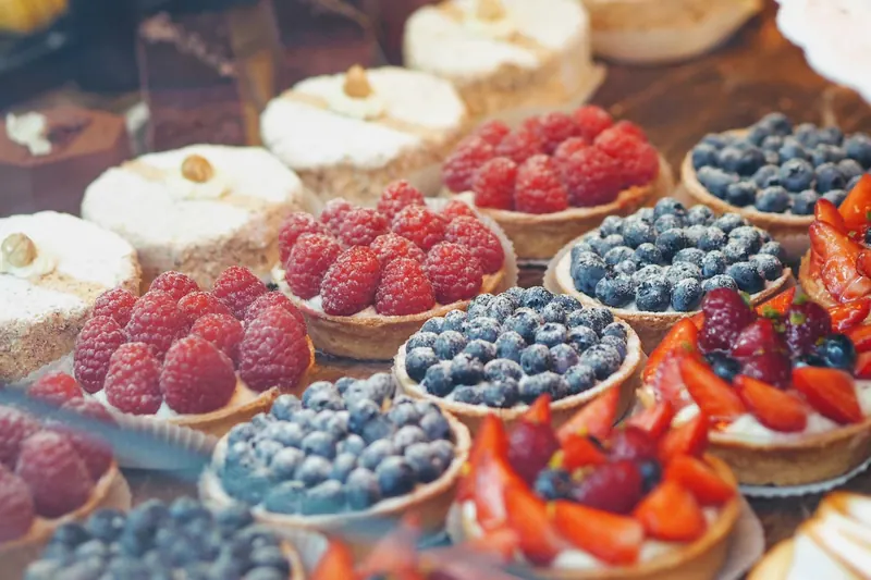 La vitrine de la boutique : tartelettes aux framboises, aux myrtilles et choux à la crème