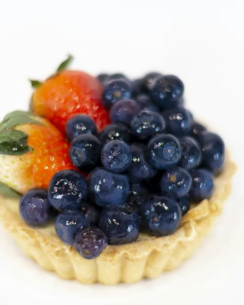 Une tartelette aux myrtilles et aux fraises sur une pâte sablée